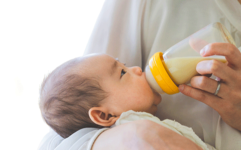 ほ乳びんでミルクを飲ませてもらっている赤ちゃん